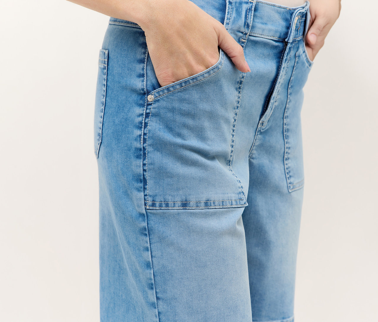 Személy kék Angels Denim »Lia Urban« rövidnadrágban, kezével a zsebében.