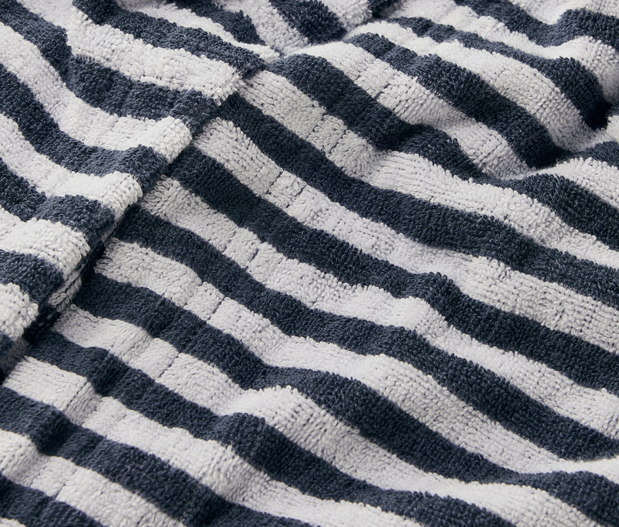 Közelkép egy csíkos törölközőről, tengerészkék és fehér csíkokkal.