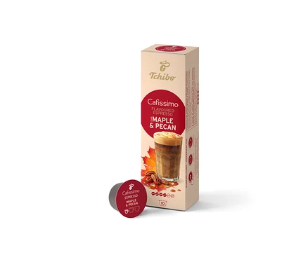 Egy bézs színű Cafissimo Flavoured Espresso Maple & Pecan (10 kapszula) doboz áll függőlegesen, előtte egyetlen sötétvörös kapszula fekszik. A dobozon kávéital, juharlevelek és pekándió látható.