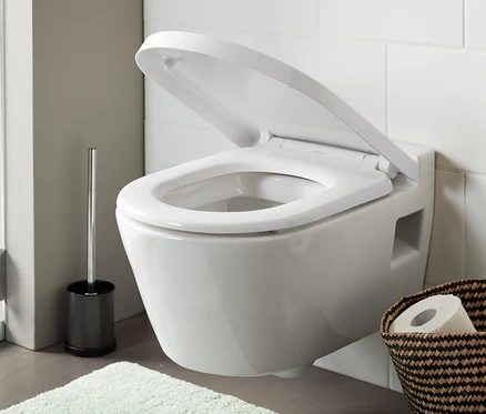 Nyitott prémium, könnyen lehajtható WC-ülőke egy fehér fürdőszobában.