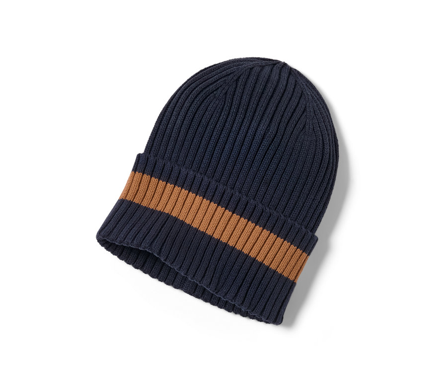 Egy sötétkék/barna kötött sapka részletének közeli képe.