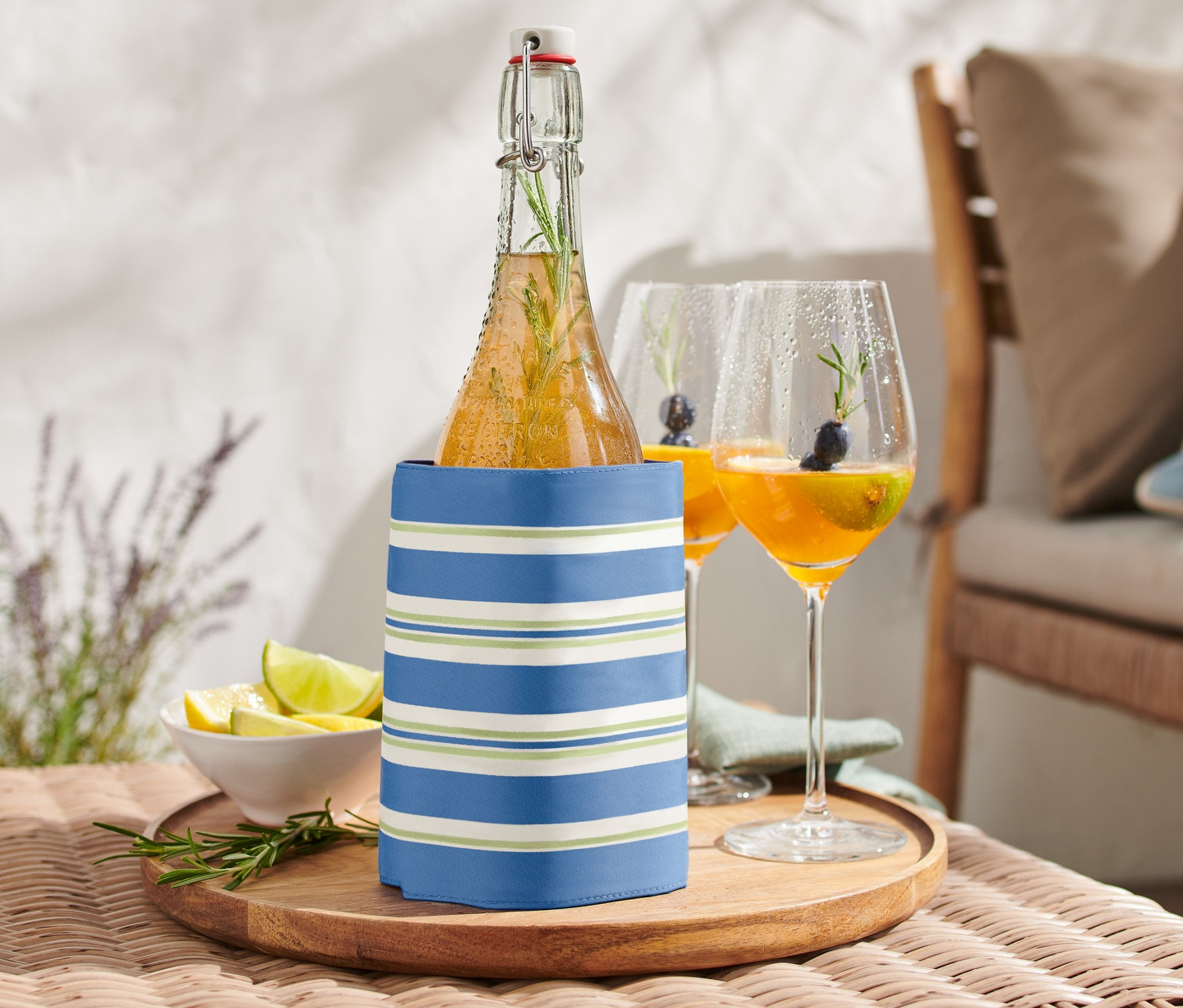 Palack hűtőköpenyben egy asztalon, két pohár ital mellett.