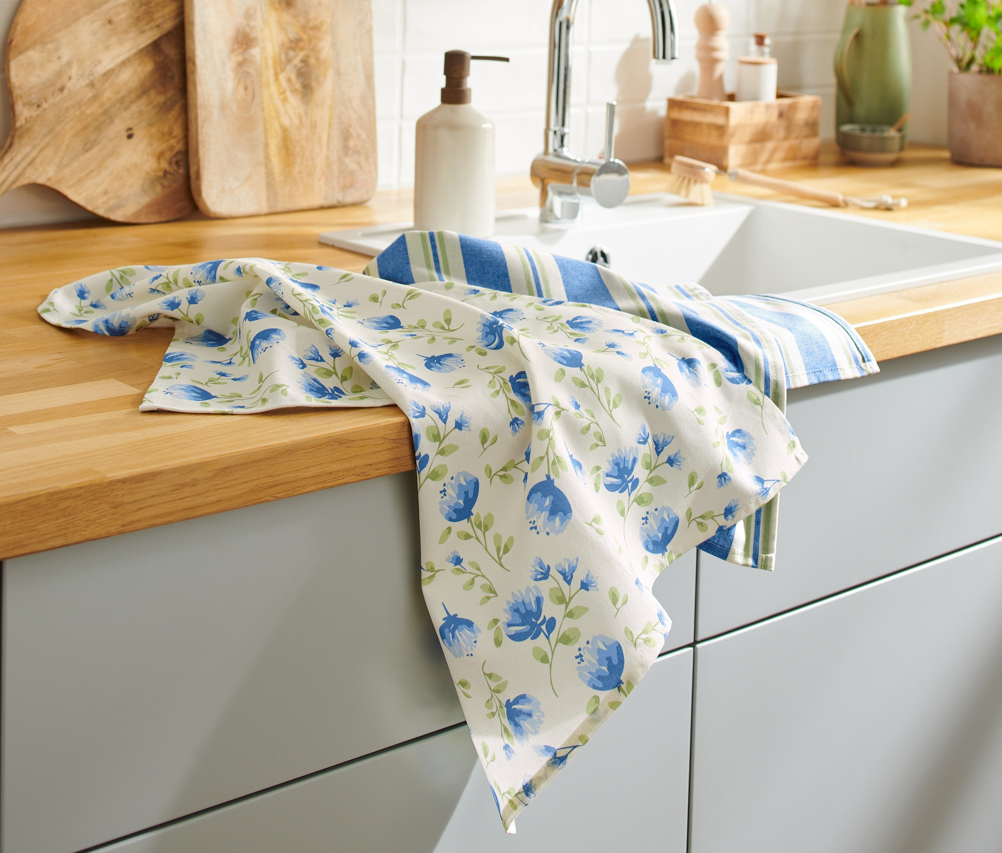 Két konyharuha van a konyhapulton a mosogató mellett.