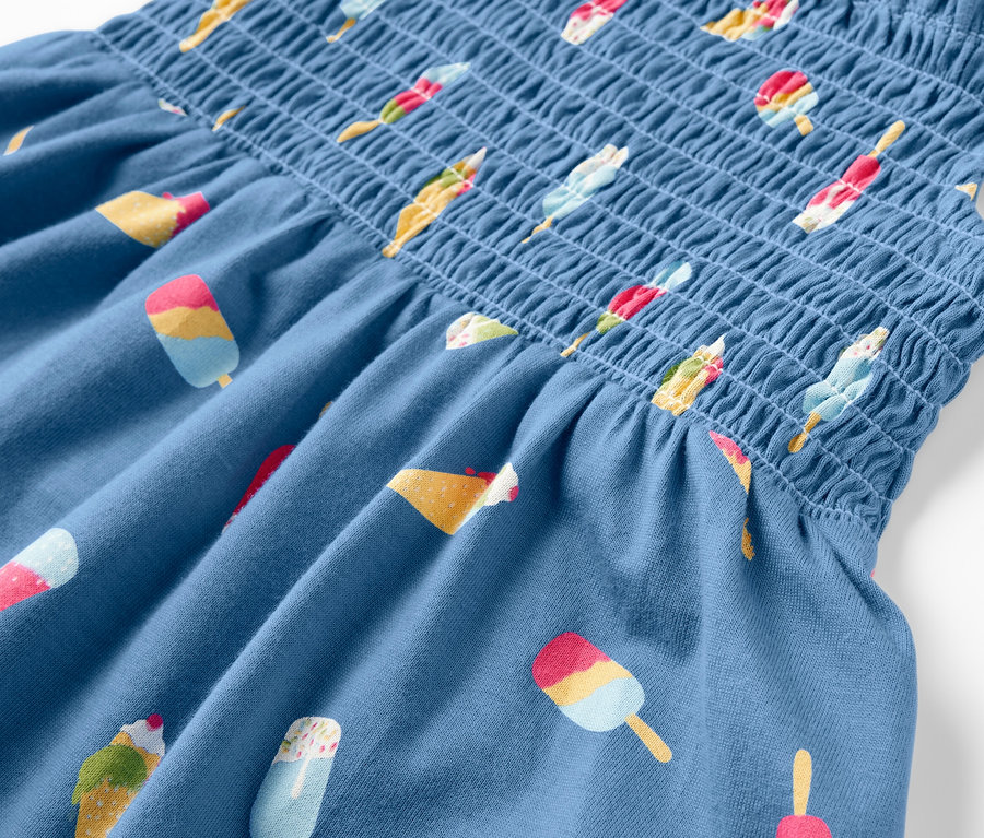 Egy kék, fagyi mintás pántos ruha részlete.