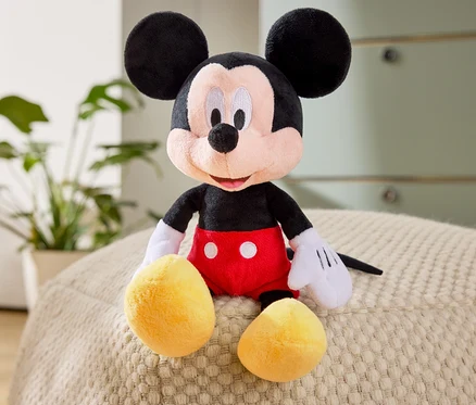 Egy Mickey egér plüssfigura ül egy puffon.