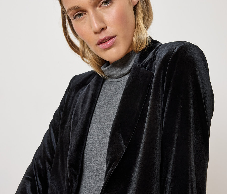 Nő visel fekete bársony blézert és szürke garbót.