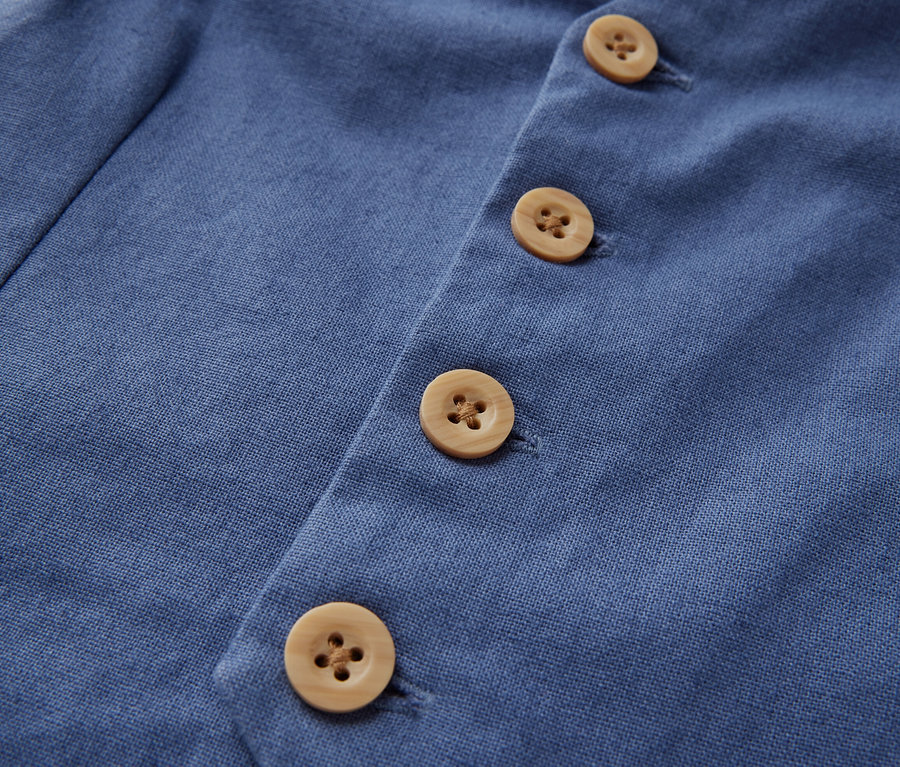 Egy gyerekmellény részlete gombokkal.