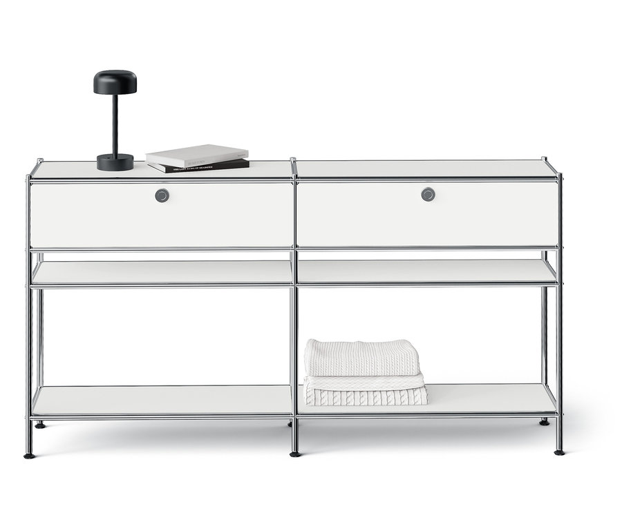 Fehér moduláris tárolórendszer két fiókkal, nyitott polcokkal és egy lámpával a tetején.