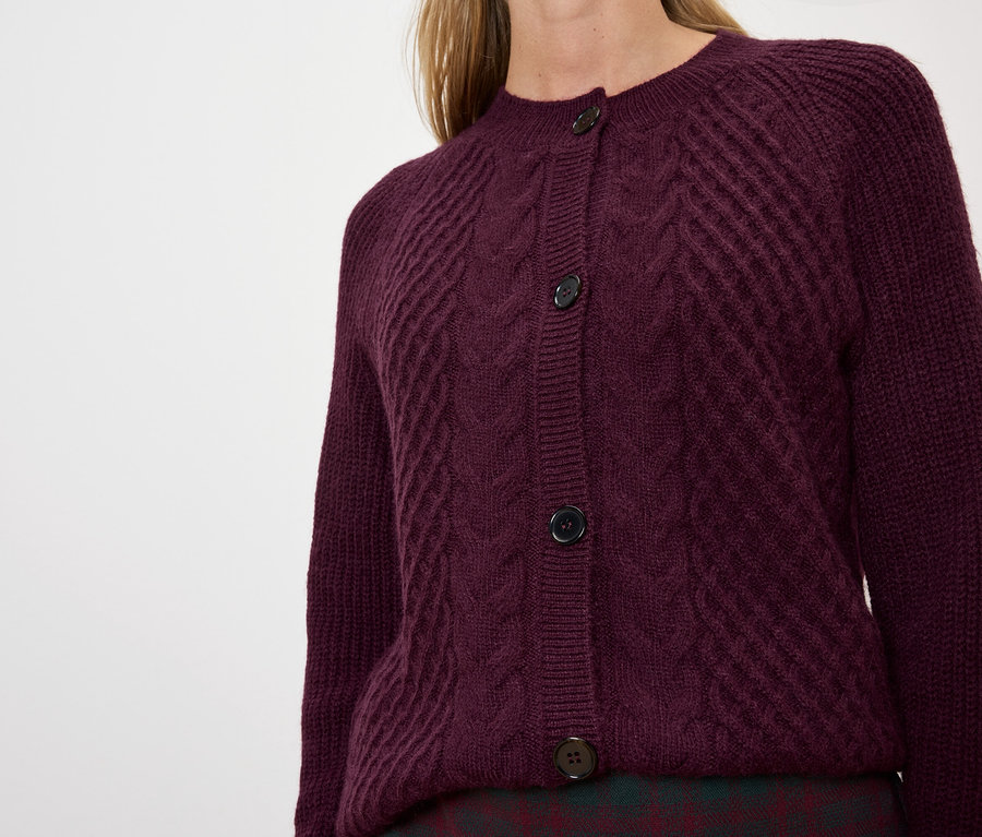 Nő visel egy lila kötött kardigánt.