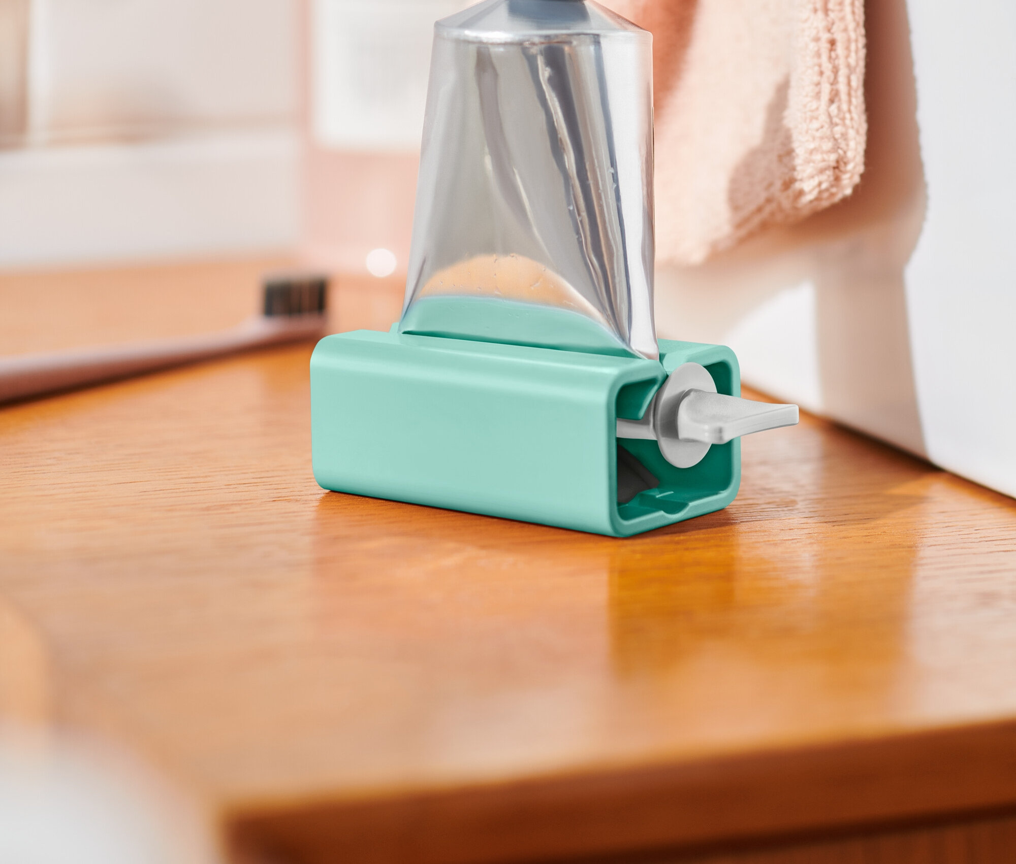 Ezüst színű tubus kék tartóban áll egy fa felületen.