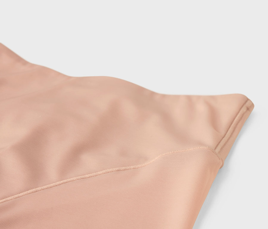 Egy varrott bézs szövet közelképe.