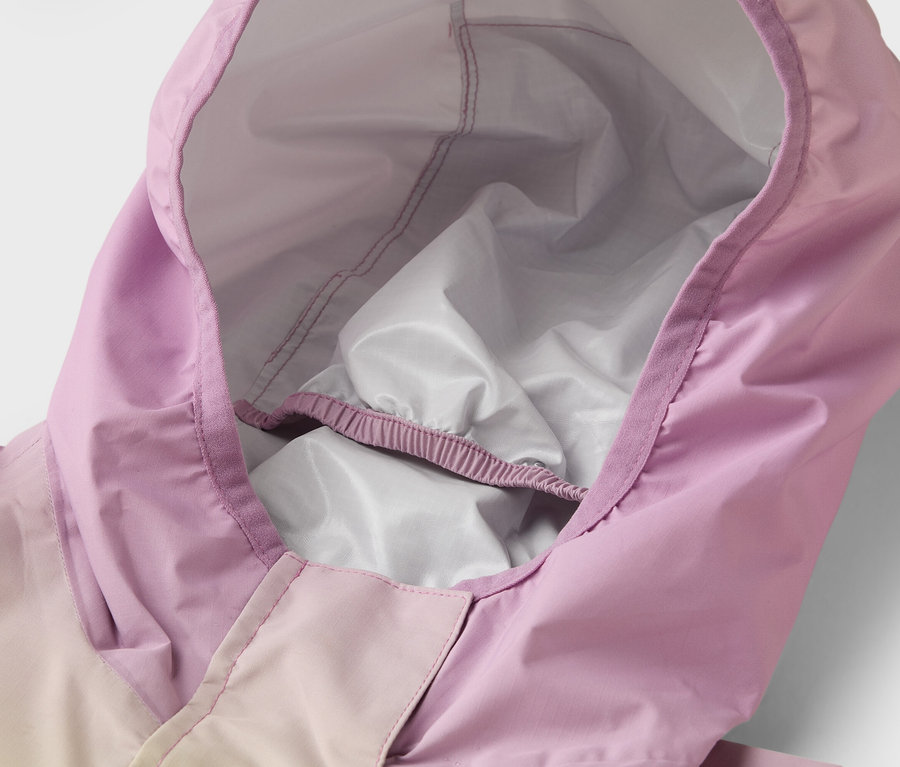 Egy lila esőkabát kapucnijának közeli felvétele fehér béléssel.