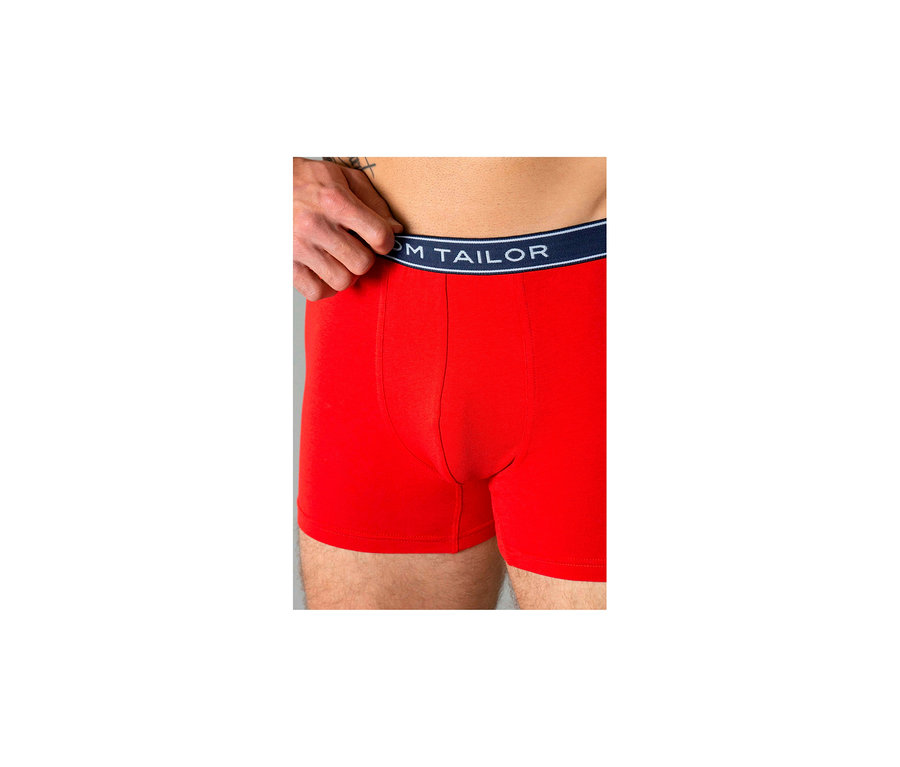 Férfi visel piros Tom Tailor „Buffer” boxeralsót; egy kéz húzza fel a sötétkék derékpántot.