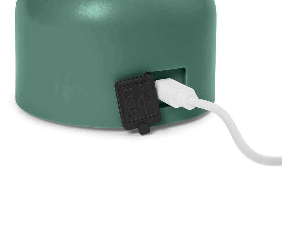 Közeli kép egy mentazöld eszközről, csatlakoztatva egy USB-kábellel.