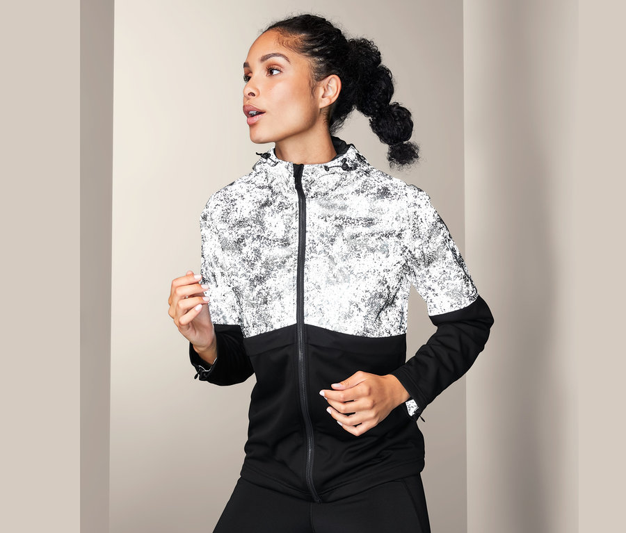 Nő visel fényvisszaverő softshell dzsekit.