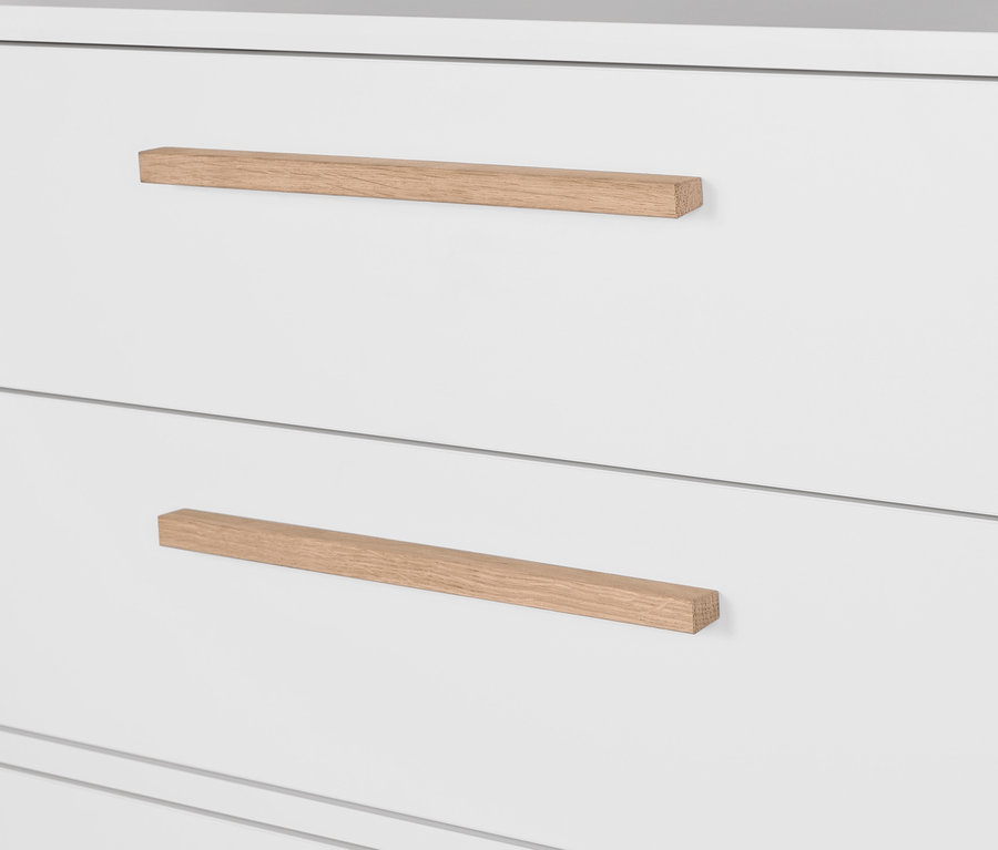 Egy fehér »Eklund« komód részlete ruhasínnel és fa fogantyúkkal.