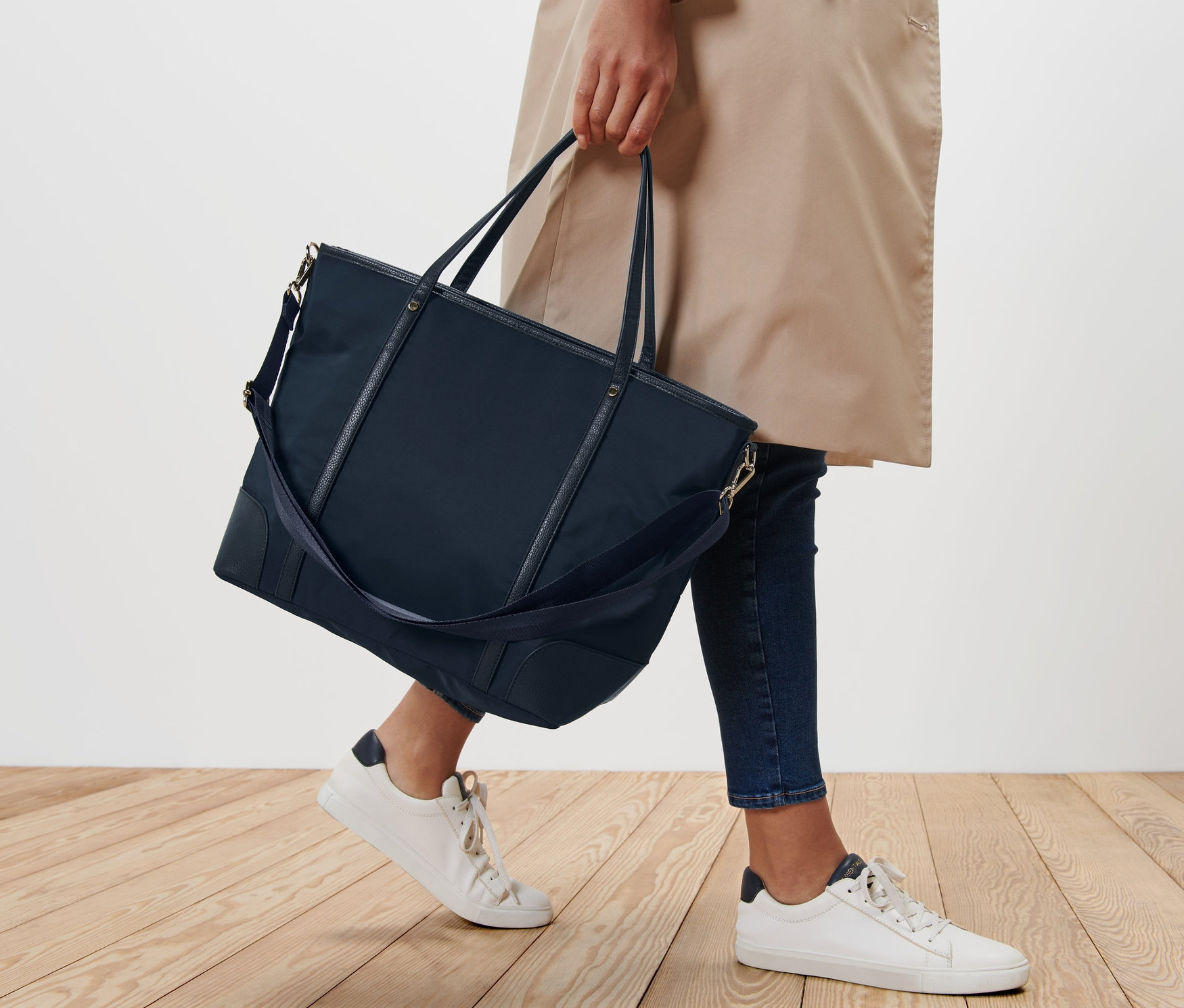 Nő sétál és egy shopper táskát visz.