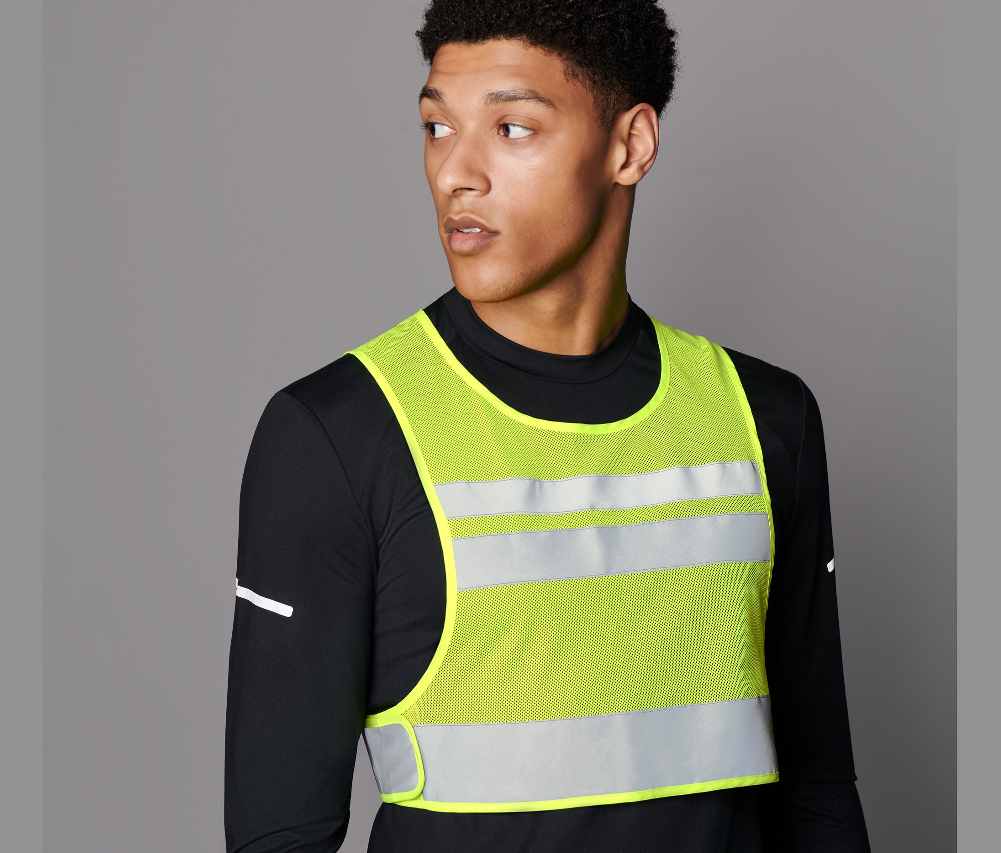 Férfi fényvisszaverő mellényt visel.