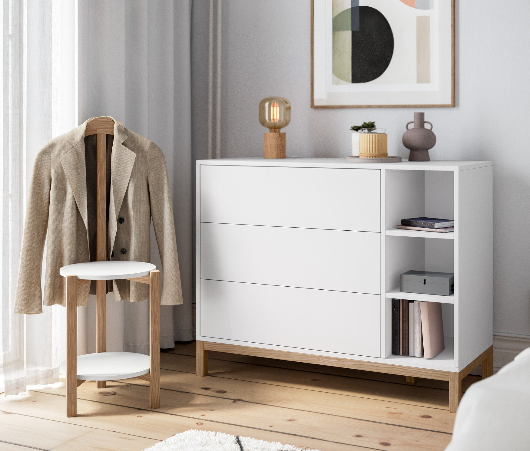 A szobában egy fehér/fa komód, egy fa asztali lámpa és egy fehér/tölgy szobainas található.