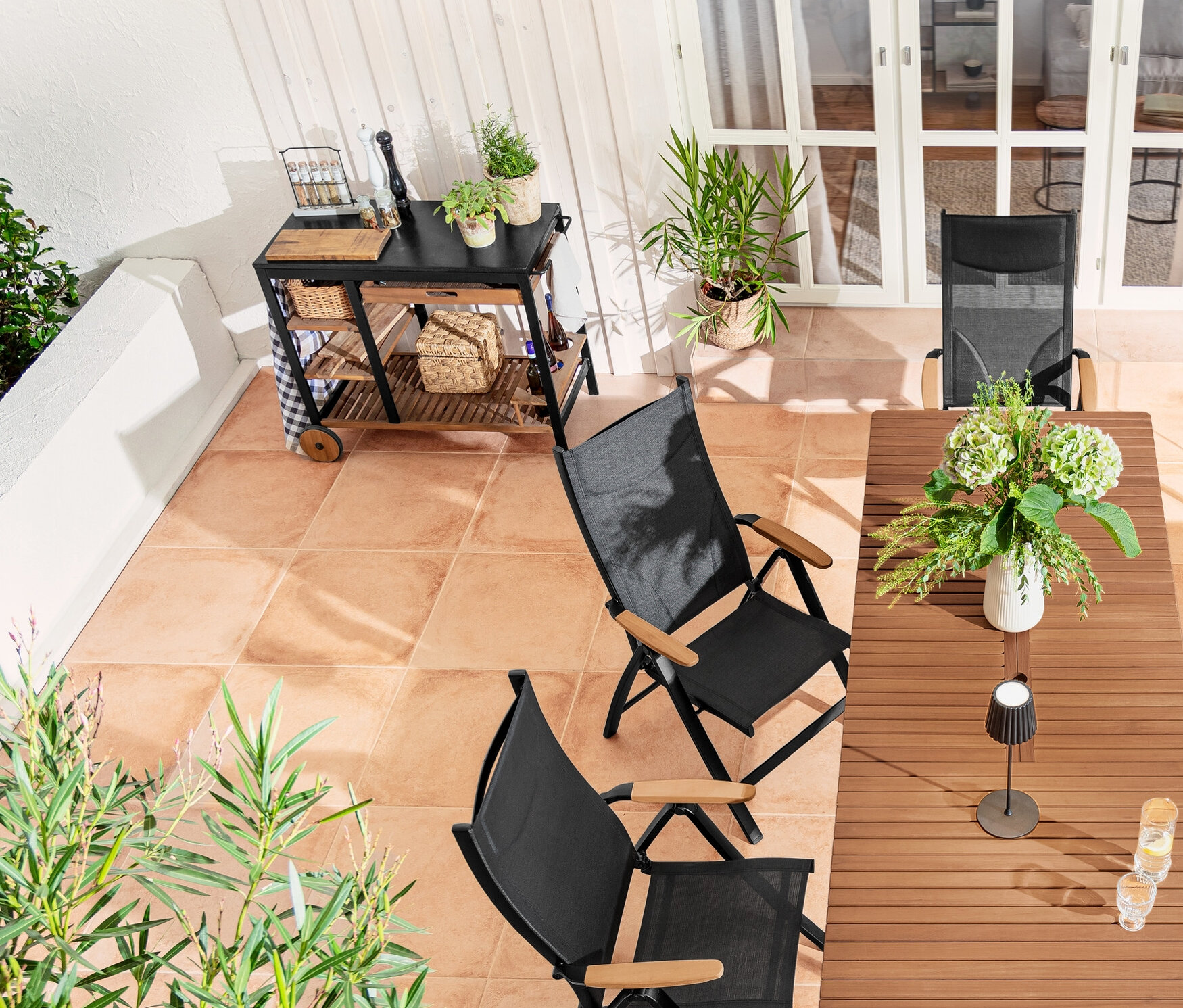 Kültéri terasz »Elin« grillkocsival, »Tinus« térelválasztó virágládával, LED-es akkumulátoros kültéri állólámpával és állítható háttámlás székkel.
