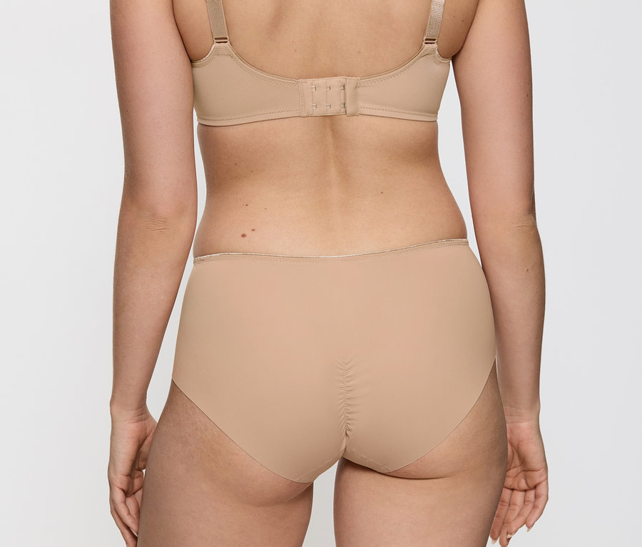 Hátulról látható egy nő testszínű Triumph Essential »Minimizer W X« melltartót és alsónadrágot visel.