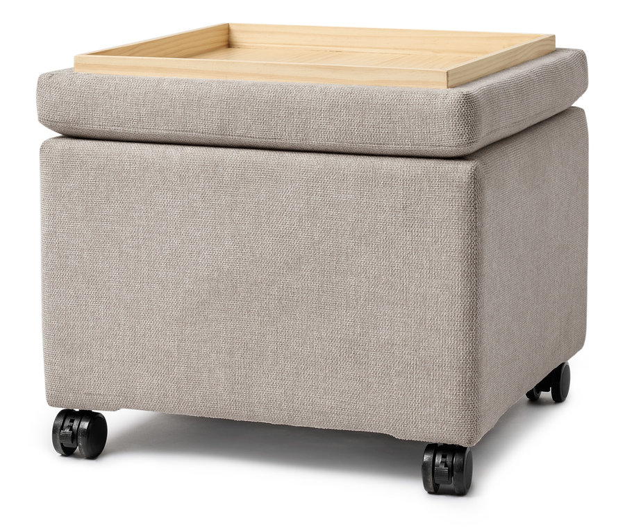Egy bézs színű szövetkocka fa tálcával a tetején és kerekekkel.