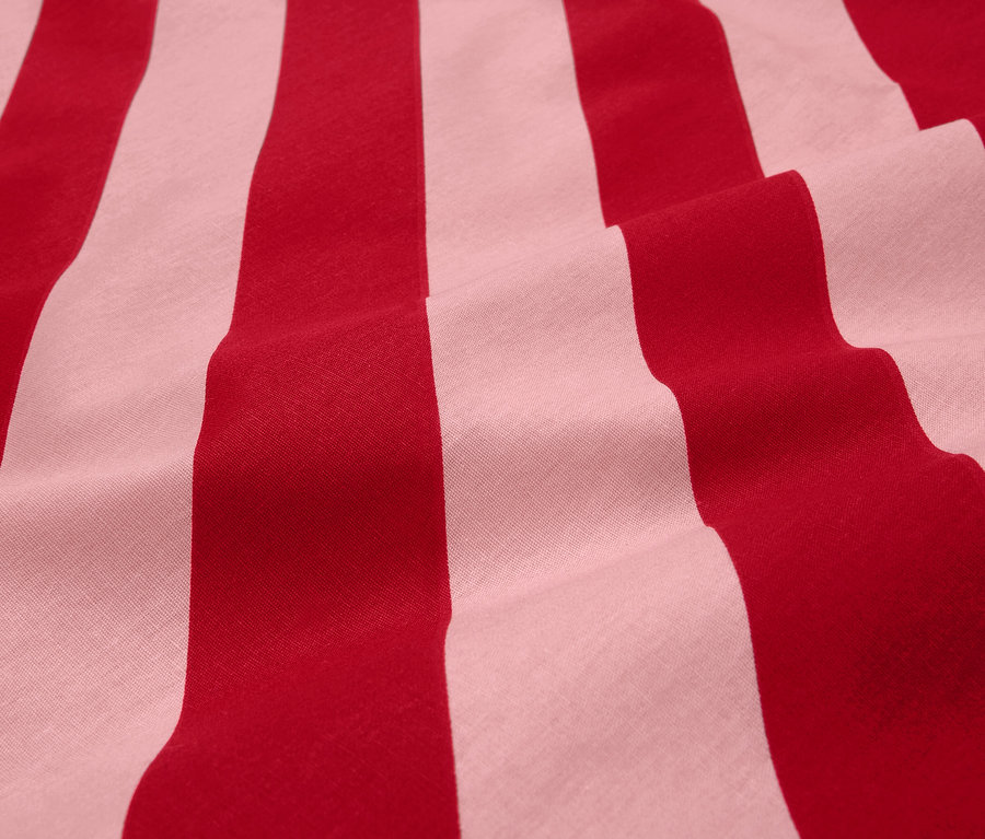 Egy piros-fehér csíkos anyag részletének közeli képe.