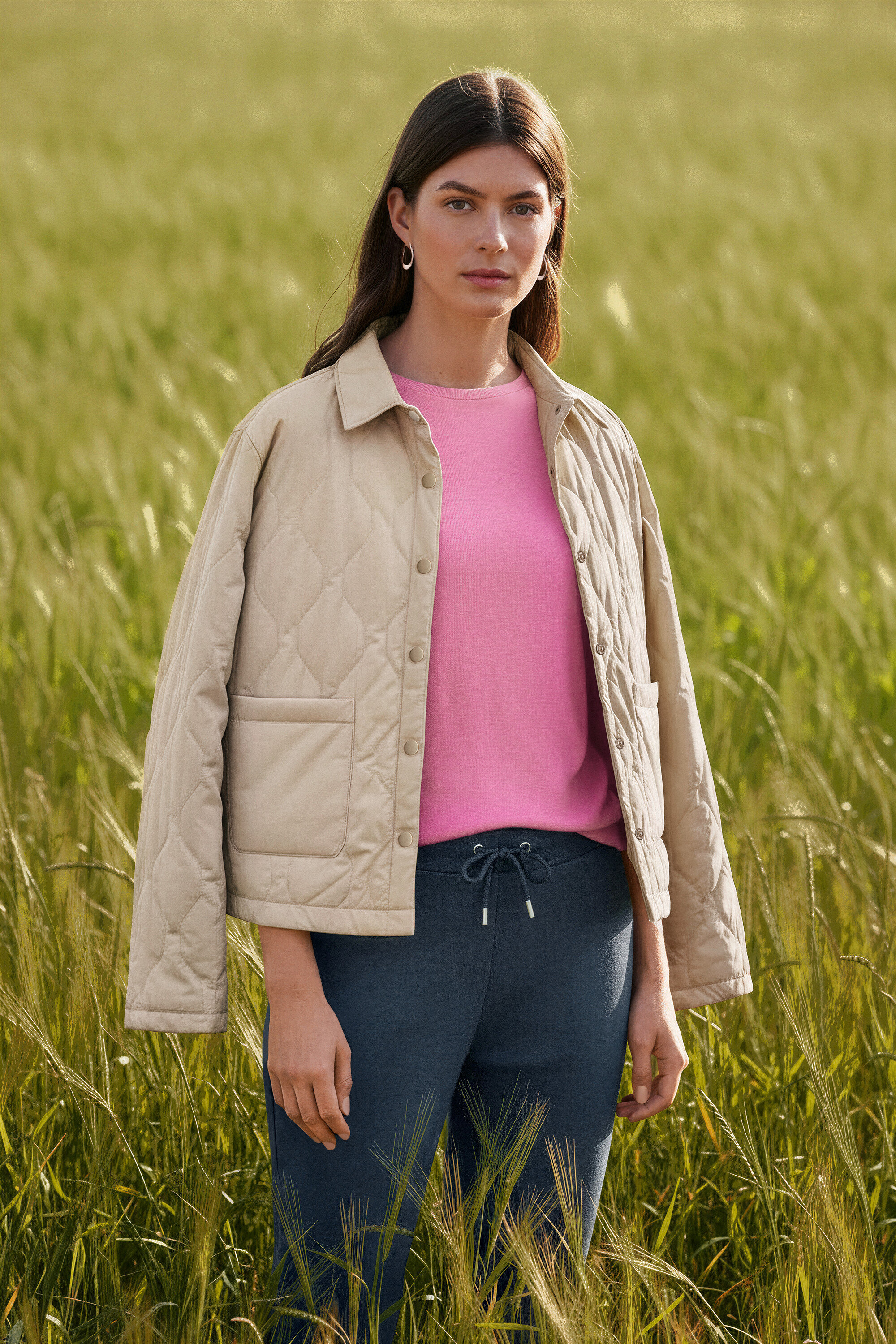 Mezőben álló nő, Wave fülbevalót visel.