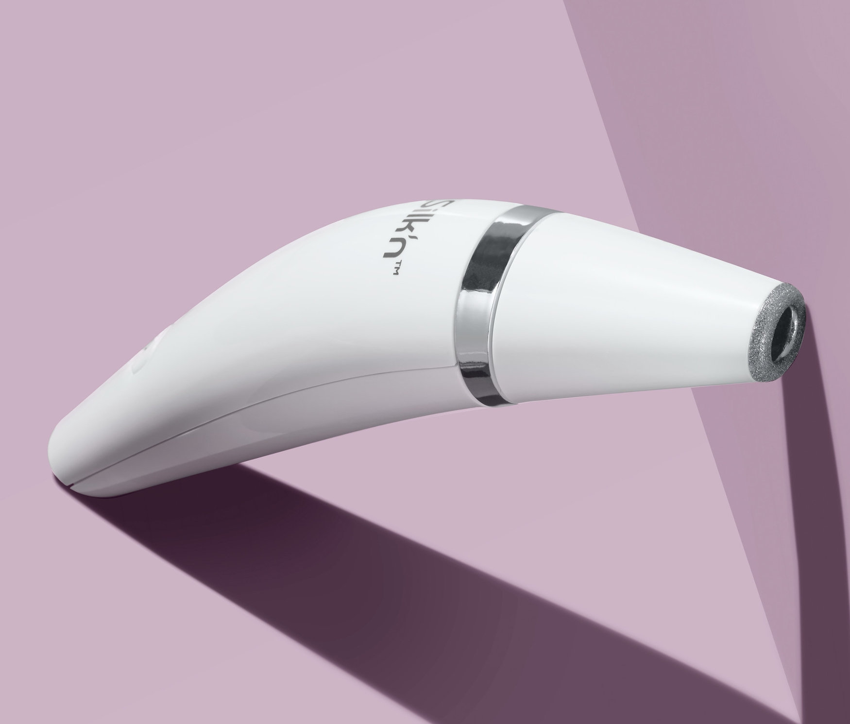 Kép egy fehér bőrcsiszoló készülékről lila háttérrel.