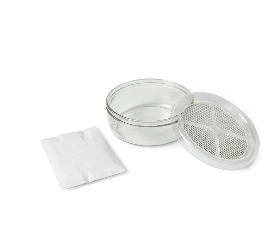 Egy csíráztatókészlet átlátszó üvegtartállyal, fedővel és egy zacskó maggal.