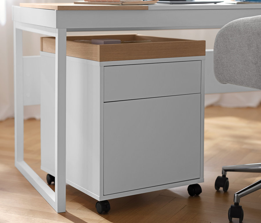 Egy fehér görgős tároló tálcával egy asztal alatt.