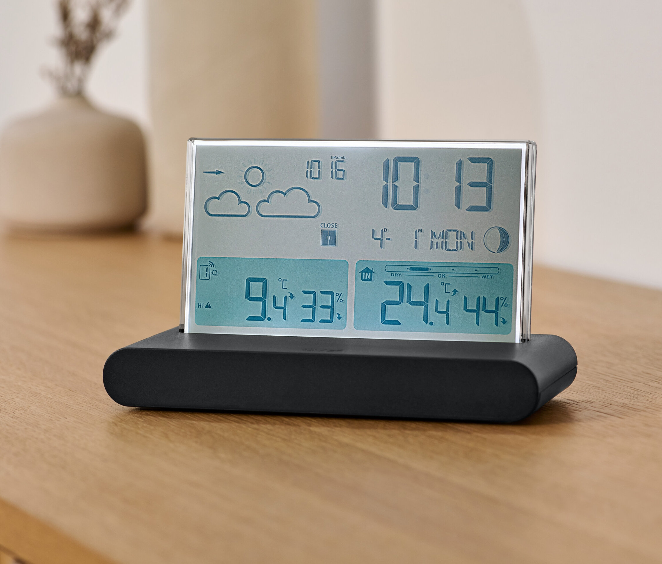 Egy rádióvezérelt időjárásjelző állomás egy fa asztalon.