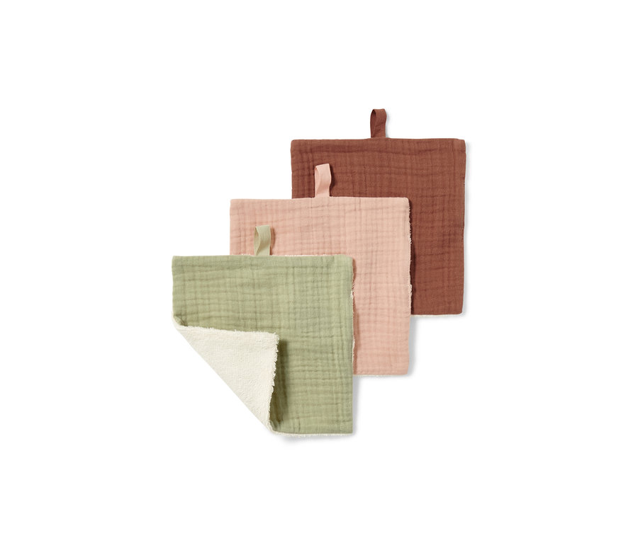 Három zöld, rózsaszín és rozsdaszínű kozmetikai kendő látható. A zöld kendő részben össze van hajtva, így a fehér oldala látható.