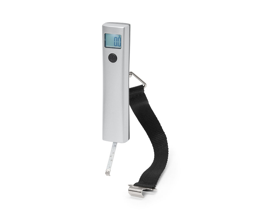 Egy digitális poggyászmérleg látható fekete hevederrel és mérőszalaggal fehér háttér előtt.