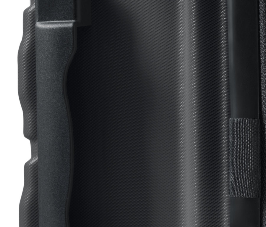 Nagy méretű kemény bőrönd részlete, amely egy fogantyút és egy texturált felületet mutat.