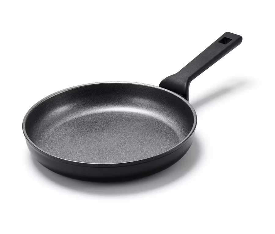 Egy kb. 24 cm átmérőjű Profi alumínium serpenyő fekete fogantyúval, fehér háttérrel.