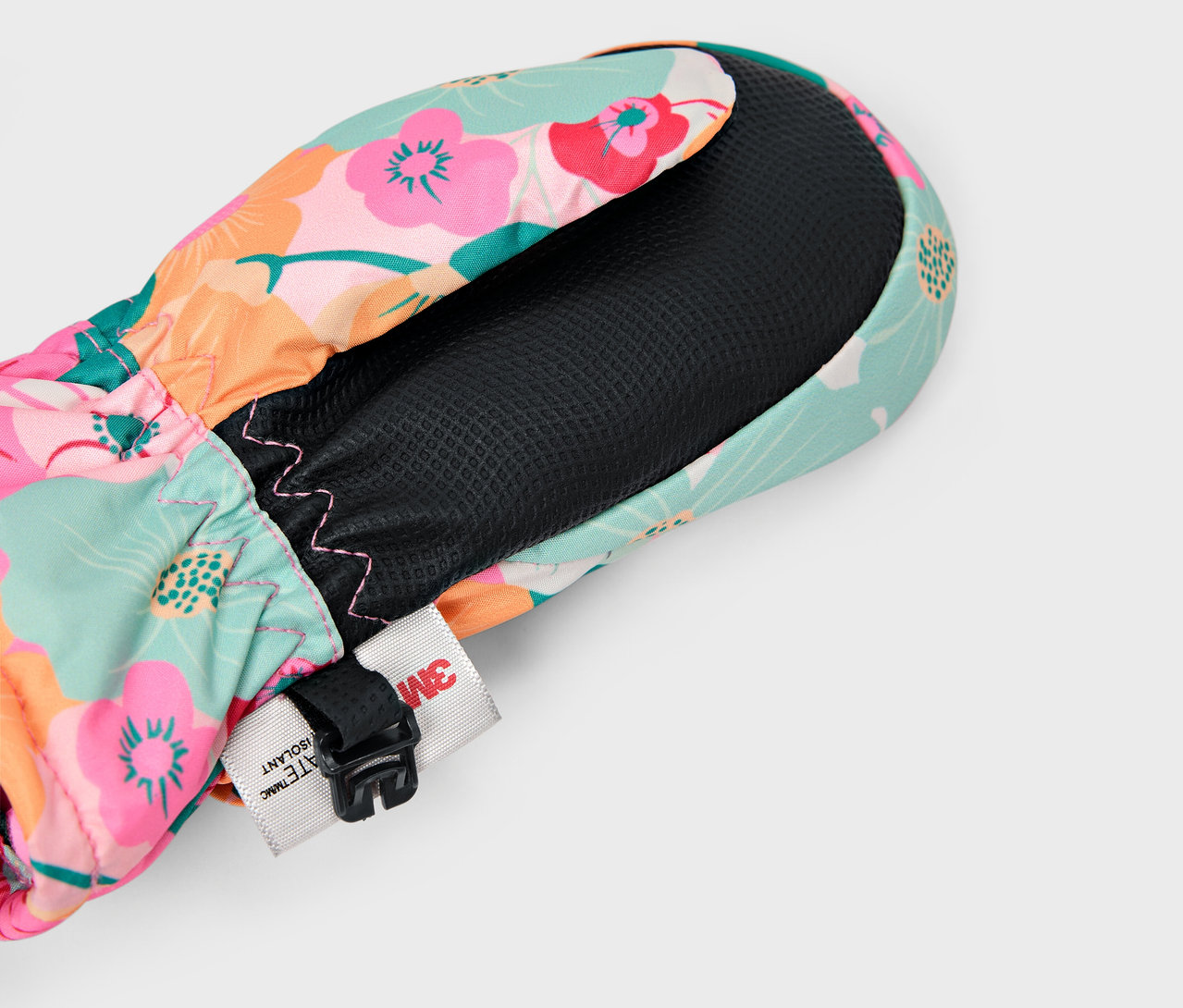 Egy színes, virágmintás kesztyű részlete fekete béléssel és állítható pánttal.