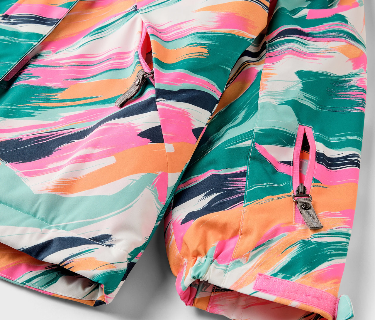 Egy színes, cipzáras kabát részlete.