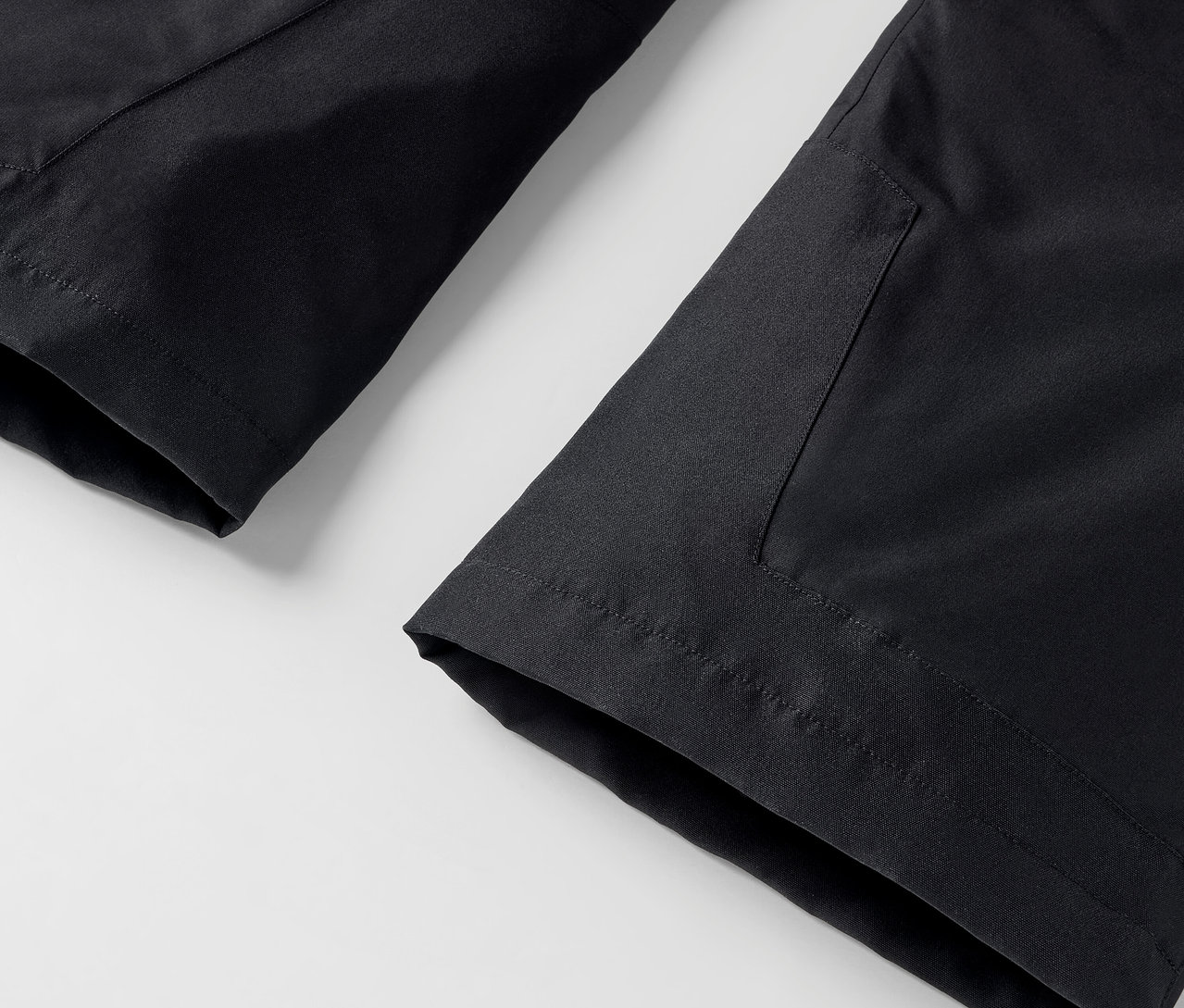 Egy fekete nadrág részlete zsebbel fehér háttéren.