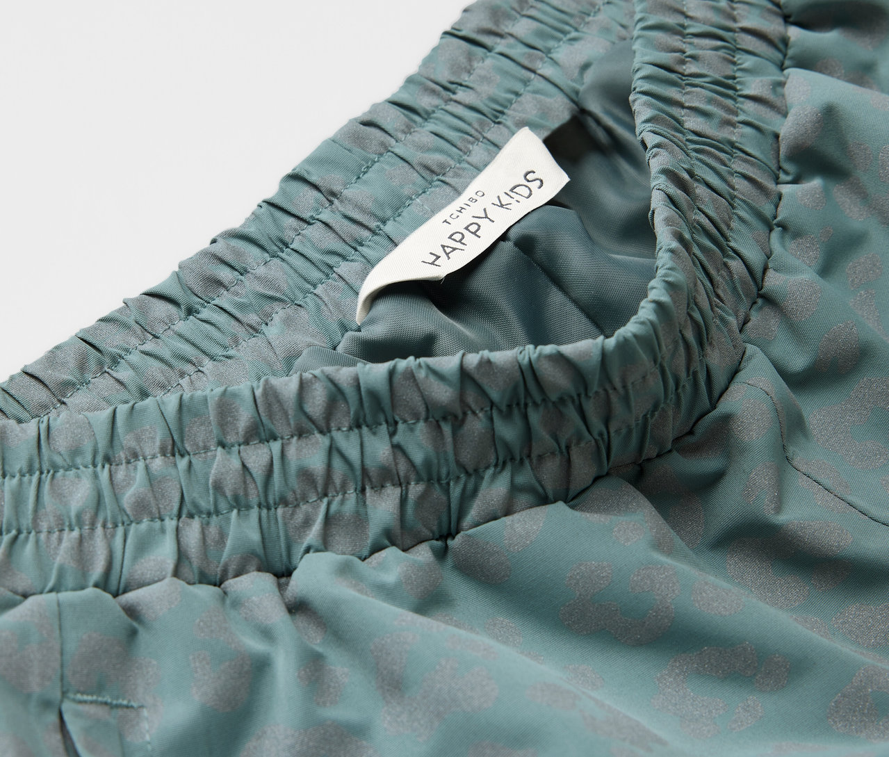 Egy gyermek esőnadrág részlete fényvisszaverő elemekkel.