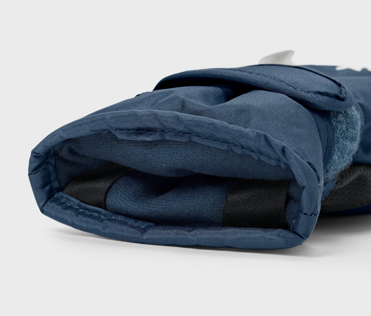 Egy sötétkék síkesztyű részletfotója.