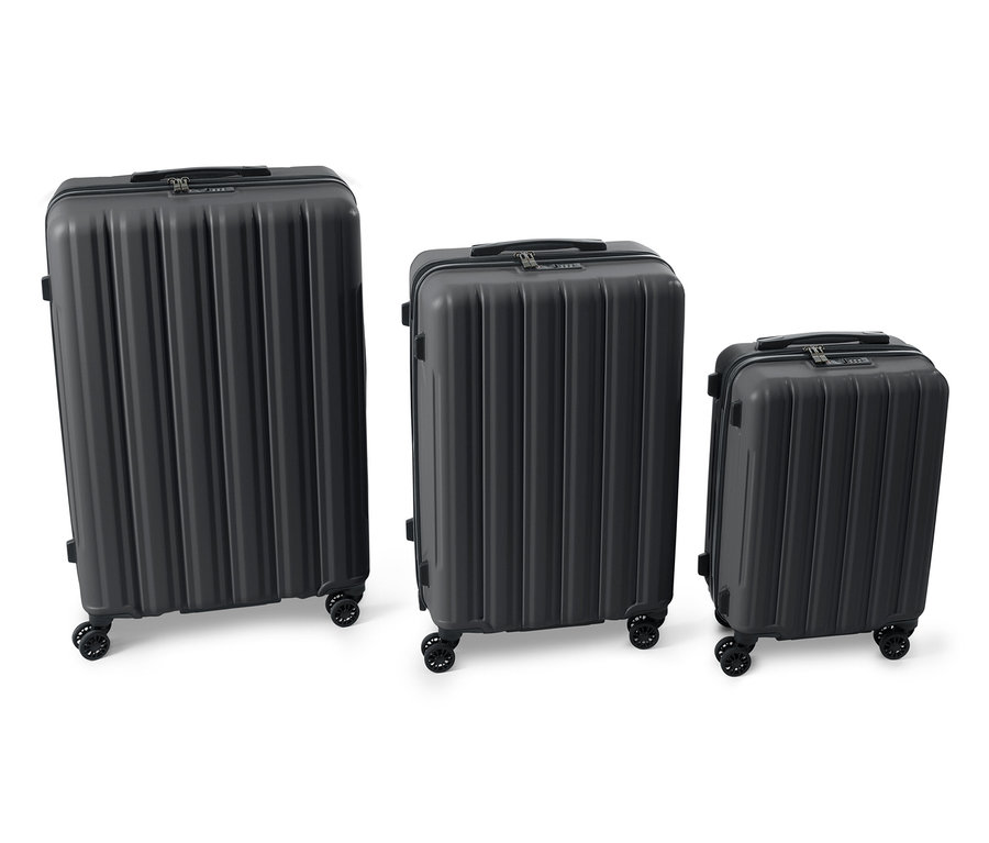 Három különböző méretű fekete kemény bőrönd egymás mellett.