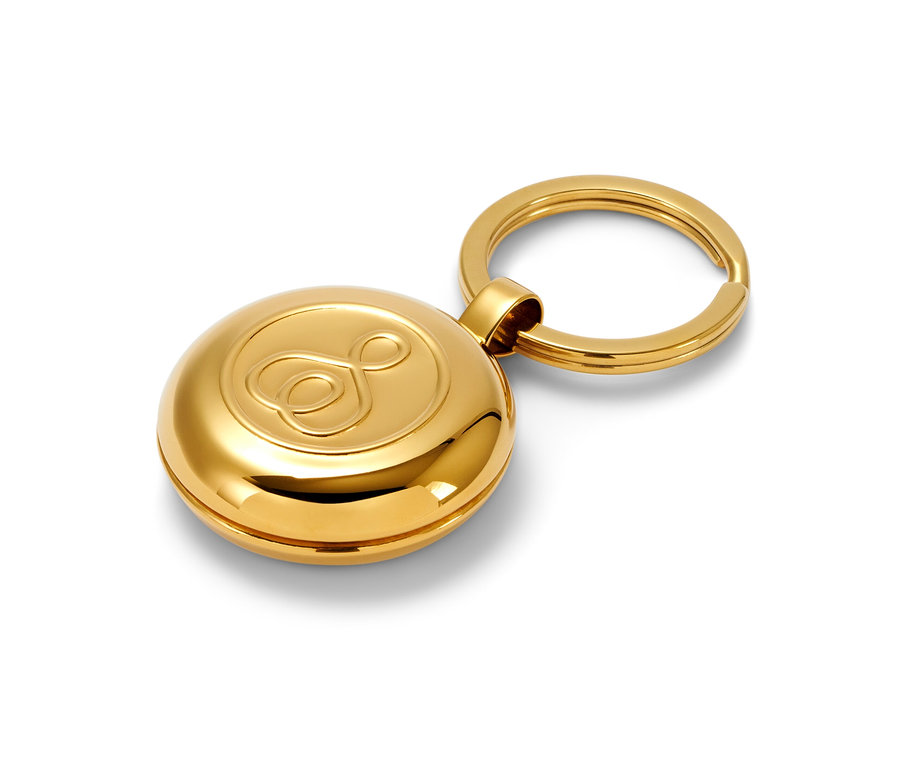 Arany gyógyszeresdoboz-kulcstartó fehér háttéren.