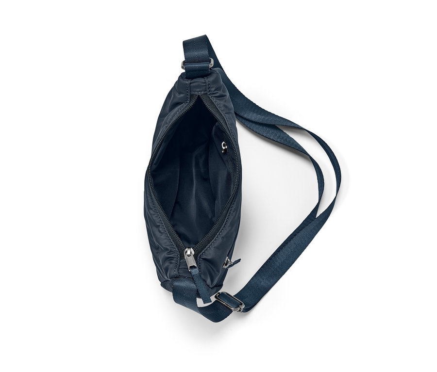 Egy sötétkék női steppelt oldaltáska részlete, nyitott cipzárral.