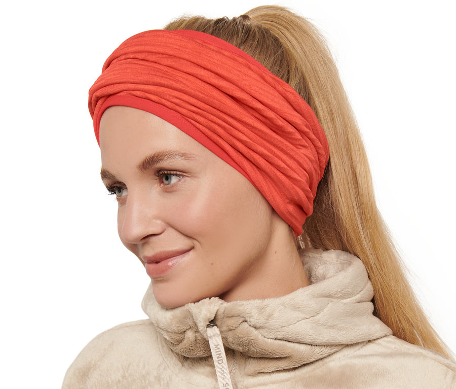 Nő visel narancssárga multifunkcionális kendőt.