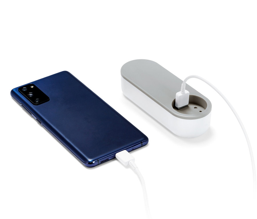 Egy sötétkék okostelefon töltődik egy külső akkumulátorról.