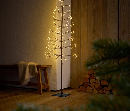 Dekoratív fa ágakkal és LED-es lámpákkal egy belső térben.