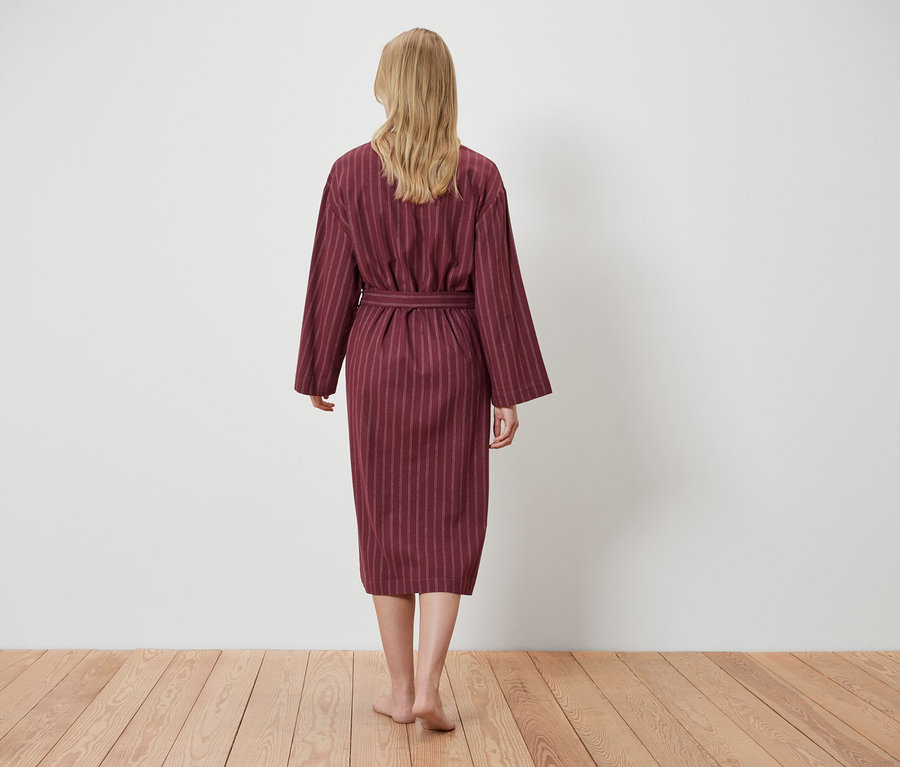 Nő visel csíkos köntöst, hátulról nézve.
