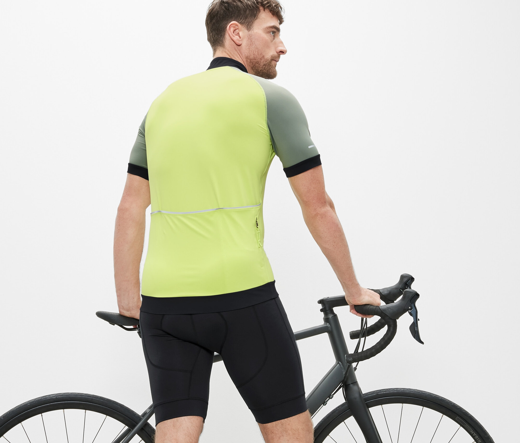 Egy férfi áll egy kerékpár mellett, és kerékpáros nadrágot visel.