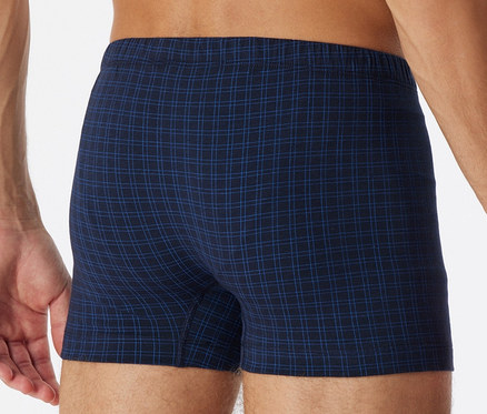 Hátulról látható férfi kockás SCHIESSER sortot visel.